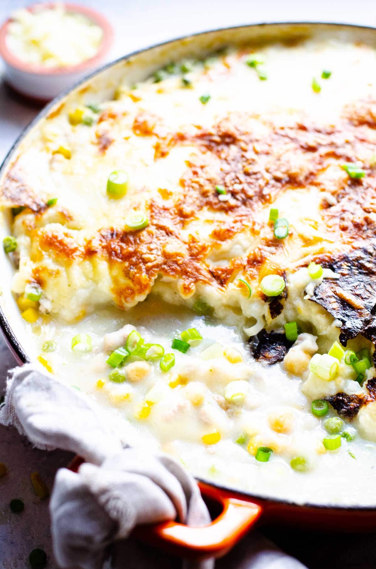 Cauliflower shepherd's pie with golden crust and saucy filling in large skillet.
