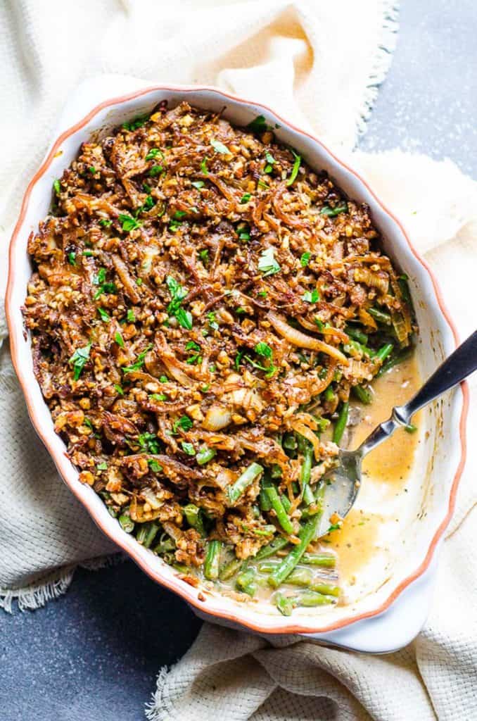 Healthy green bean casserole in baking dish with serving spoon.