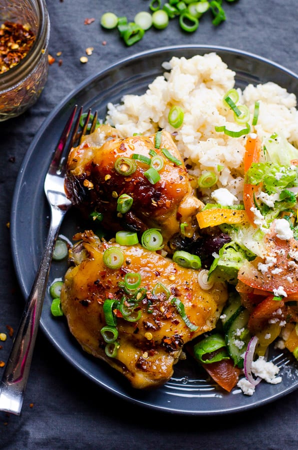 Slow Cooker Thai Chicken Thighs on plate with rice and garnish