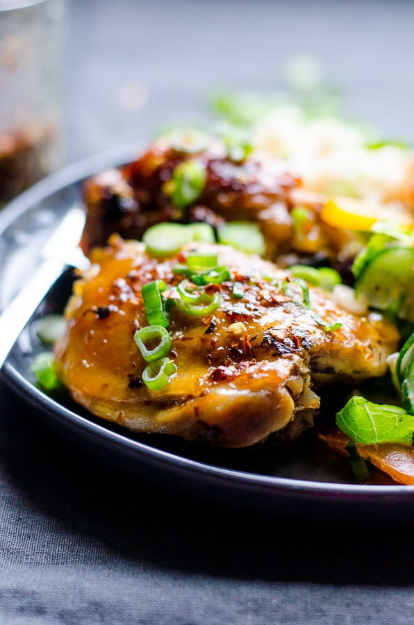 Slow Cooker Thai Chicken Thighs on a plate with green onion garnish.