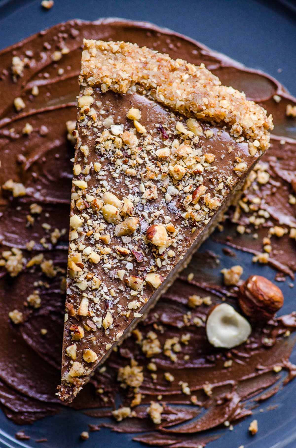 A slice of healthy nutella pie with hazelnut and chocolate garnish.