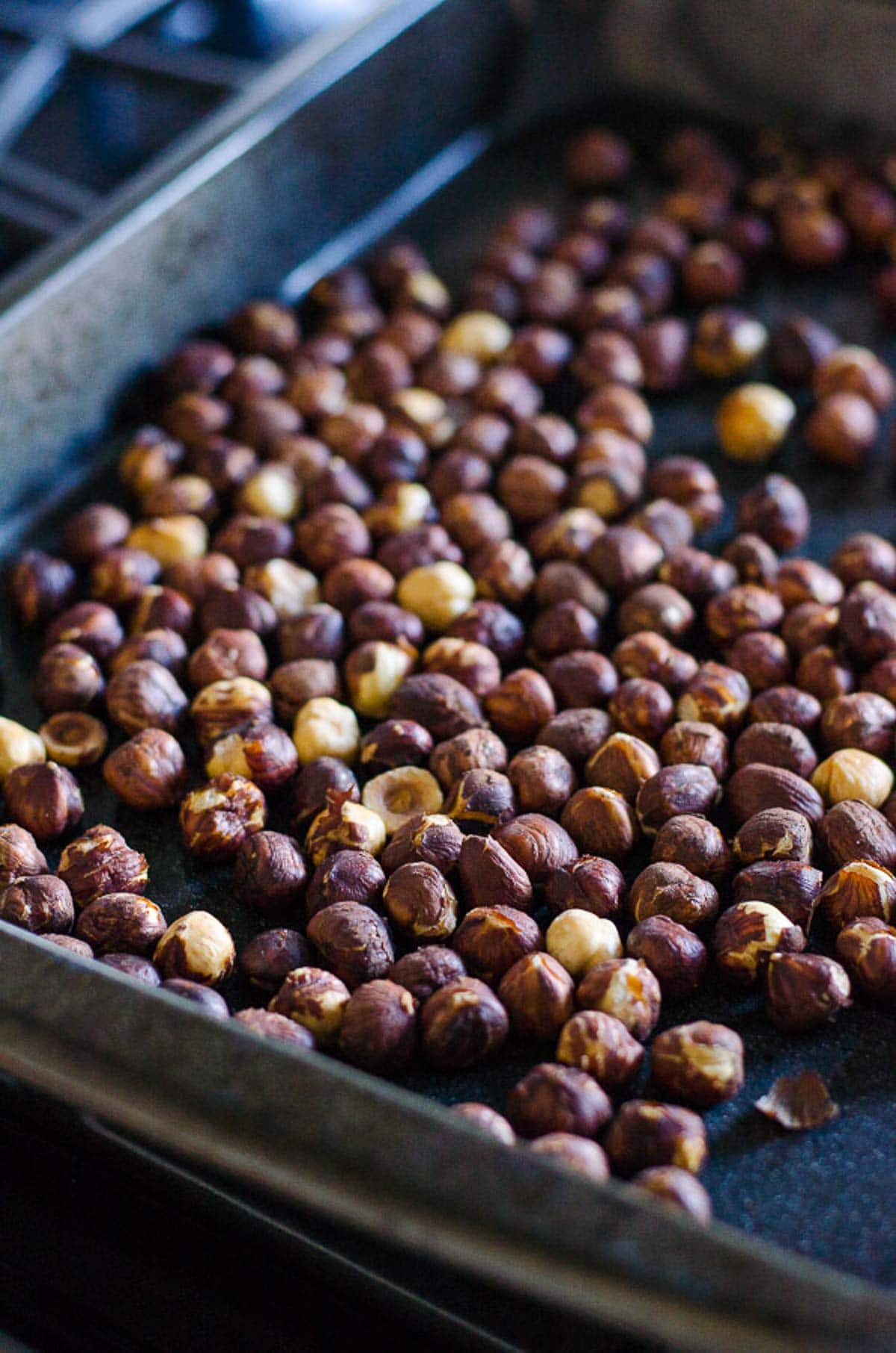 Hazelnuts on rimmed baking sheet.