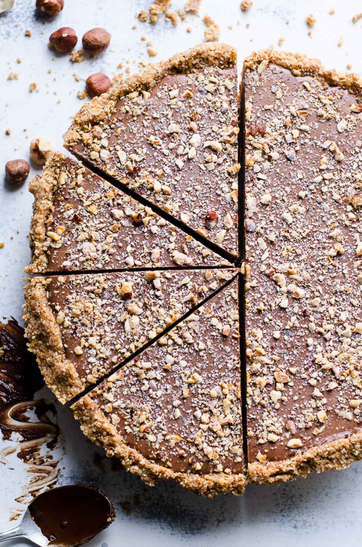 Healthy no bake nutella pie with half of pie cut into slices.