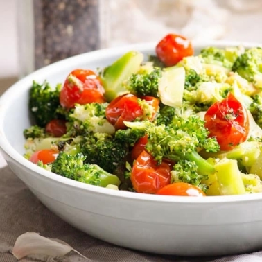 Sauteed garlic broccoli and tomatoes in the skillet.