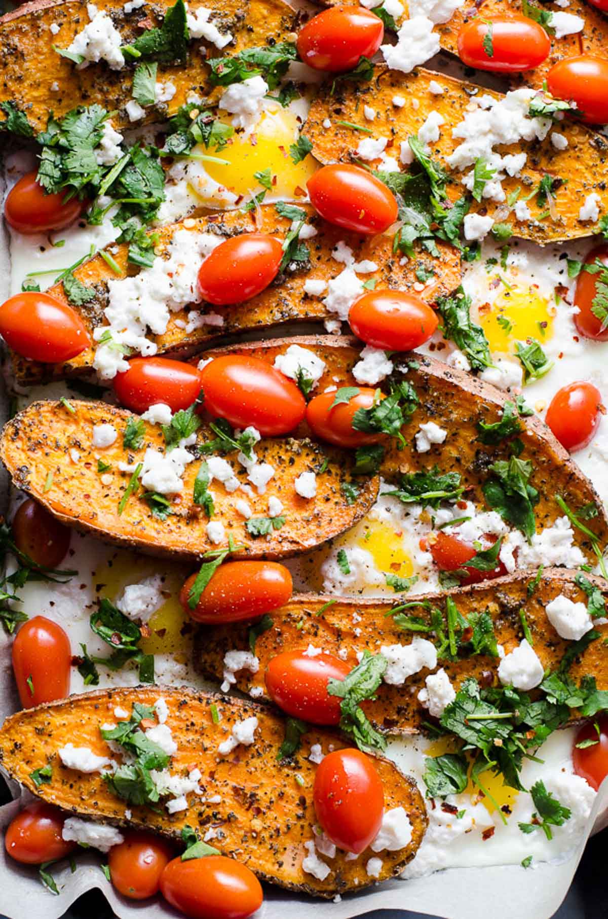 Sweet potato and eggs with tomatoes and cilantro garnish.