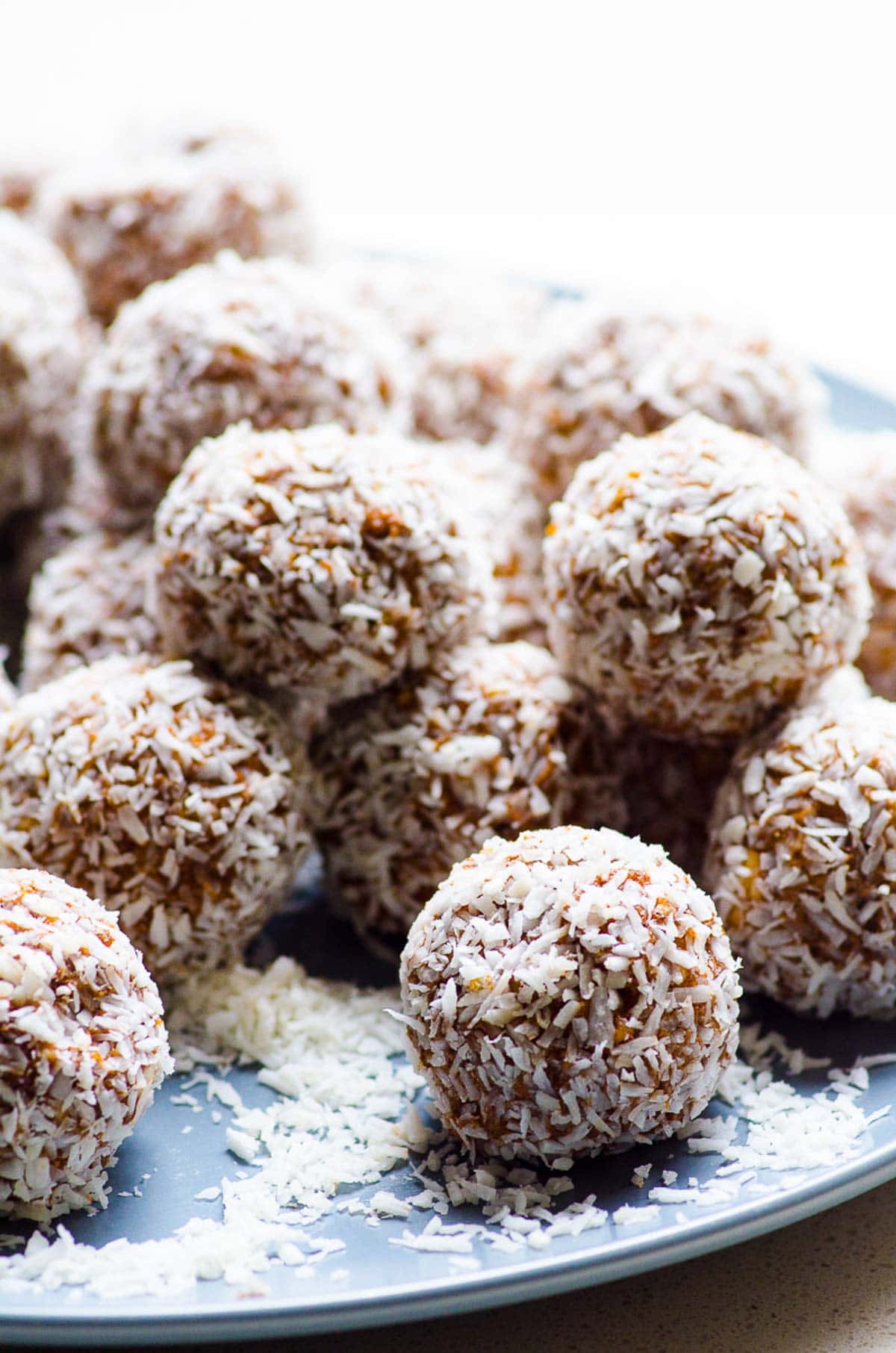 No bake protein balls stacked on a blue plate.