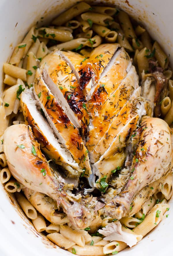Whole chicken sliced in slow cooker on top of pasta