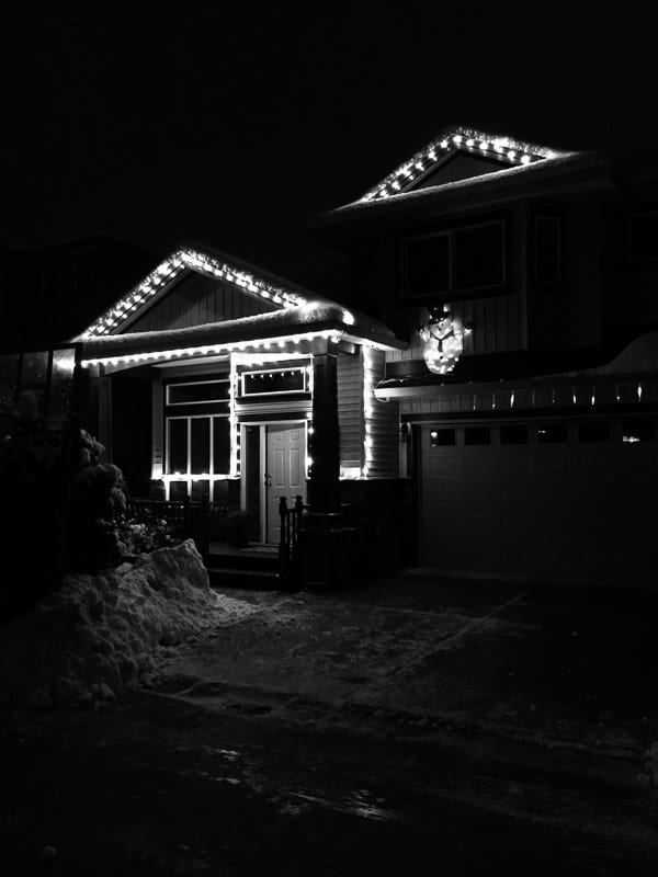 House lit up and in snow. 