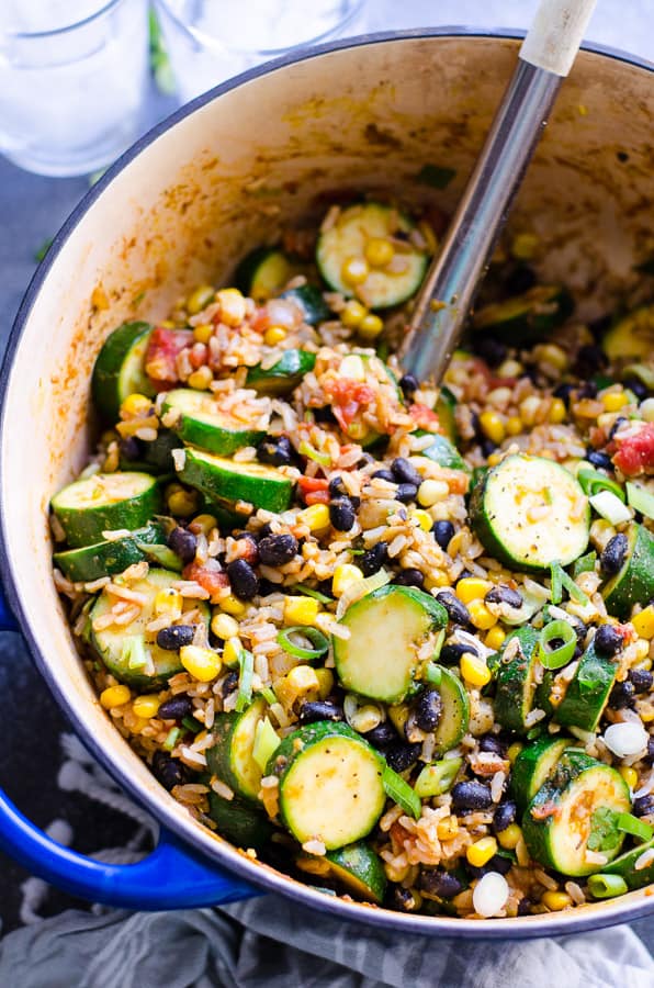 Tex Mex rice and beans with zucchini in a pot with a spoon.
