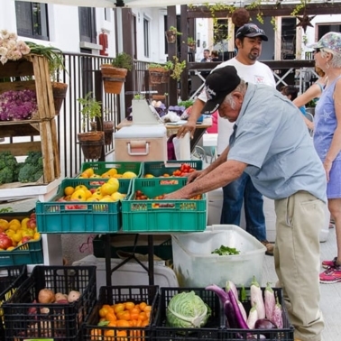 A man standing in front of a produce stand.