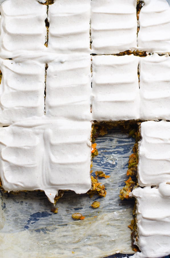 Sliced baked oatmeal breakfast bars with Greek yogurt frosting in a pan.