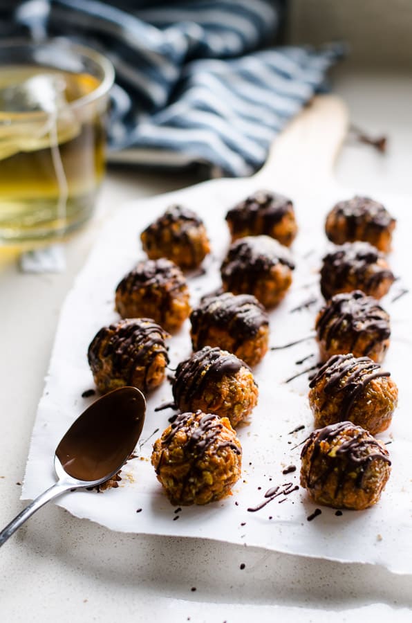 Carrot cake truffles on parchment paper with a cup of tea. 
