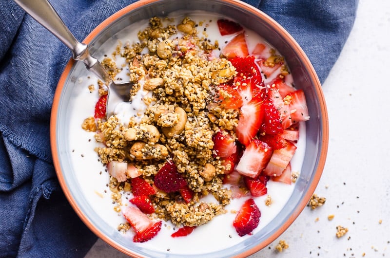 quinoa granola topped over yogurt and berries in a bowl