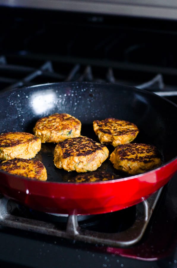 canned salmon cakes fried in red skillet