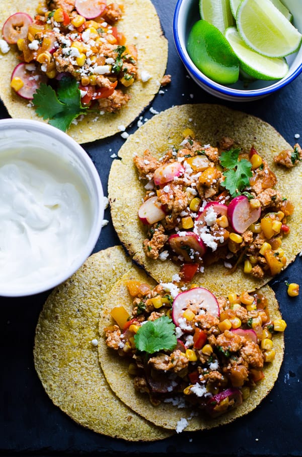 Ground chicken taco filling on three open faced tortillas.