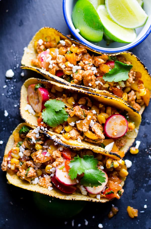 Three ground chicken tacos in tortillas with fresh cilantro.