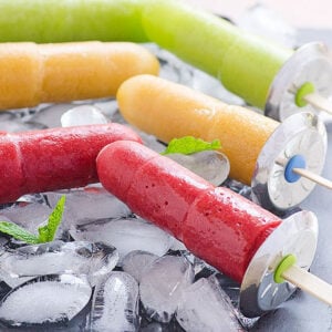 Healthy homemade popsicles on ice with mint leaves.