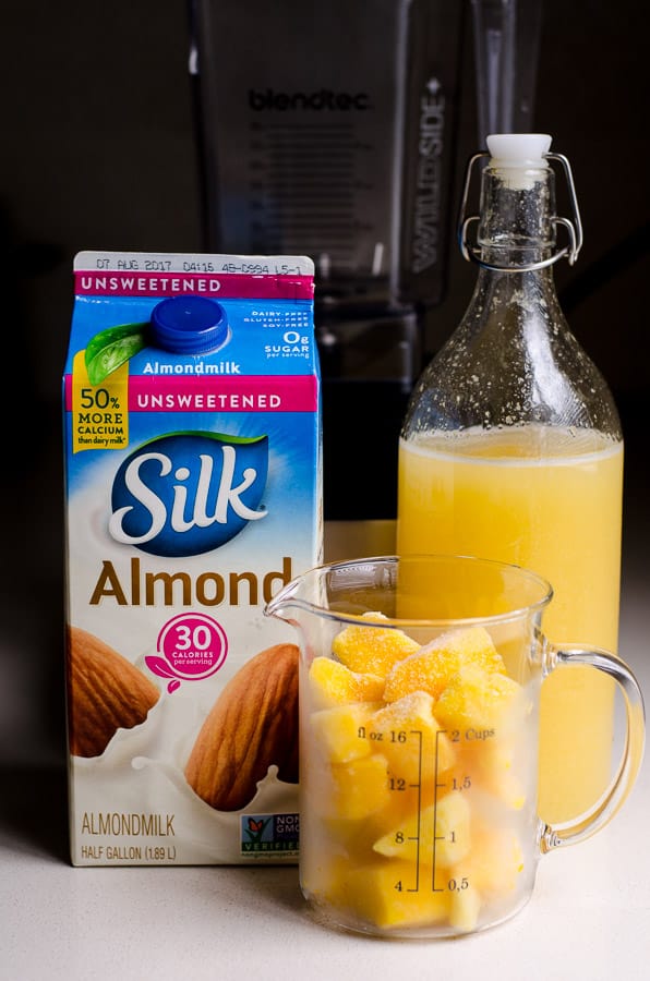 Kombucha, almond milk and cup of frozen mango.