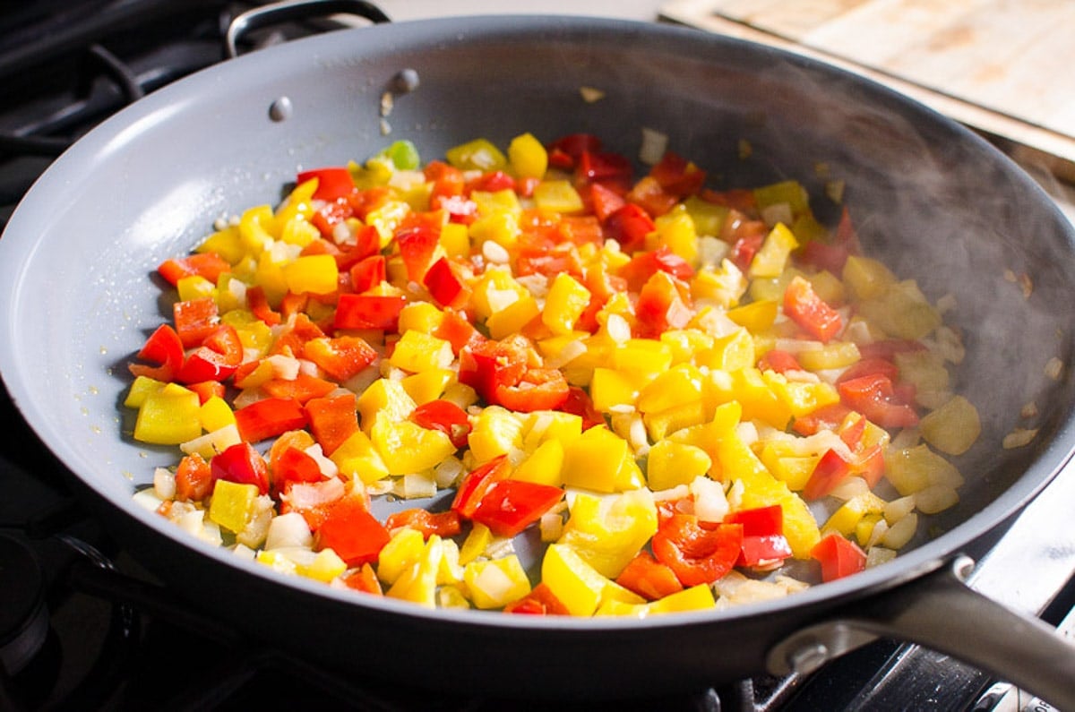 Sauteed bell peppers with onion and garlic in a skillet.