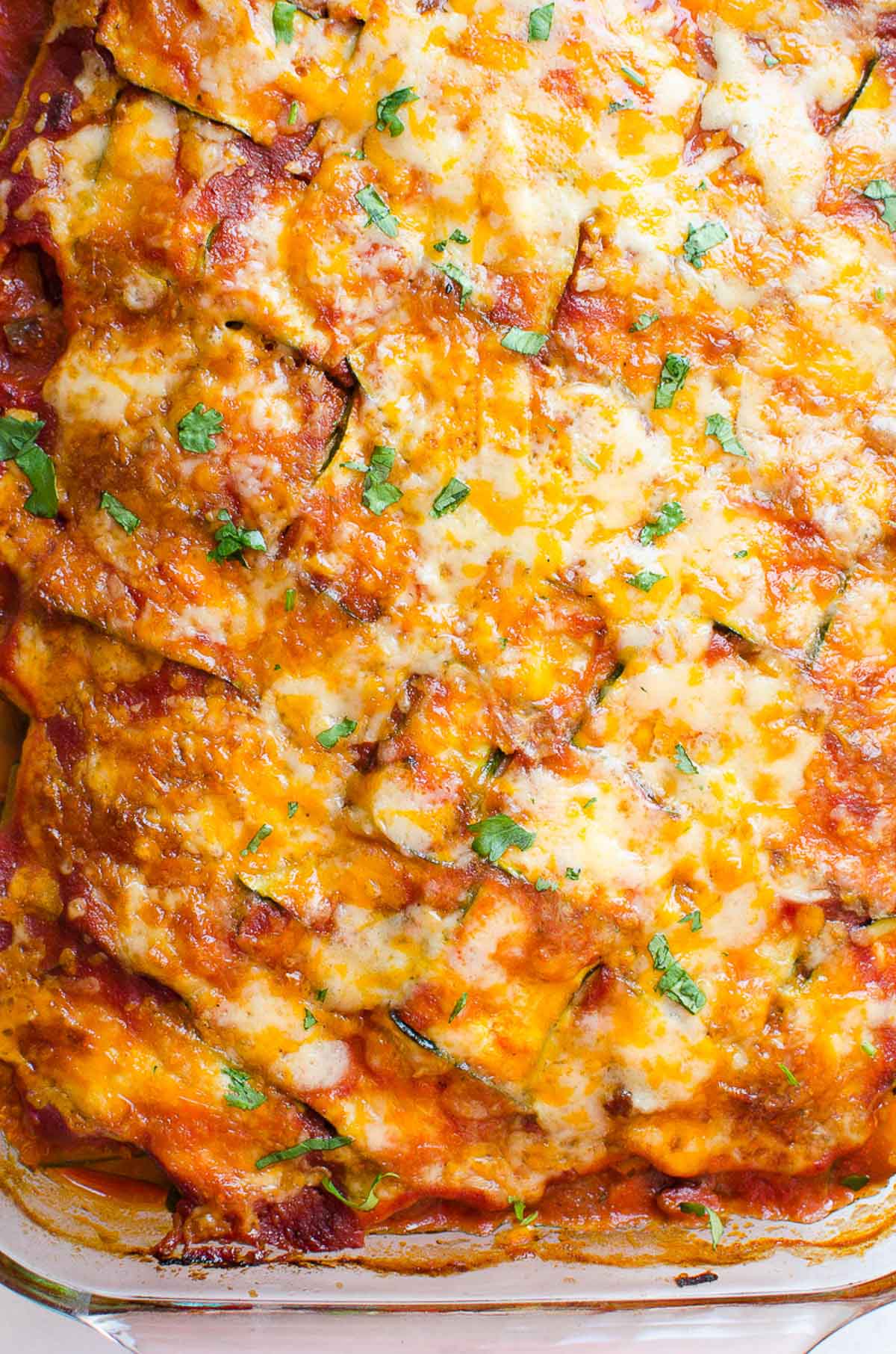 Chicken zucchini casserole in a baking dish garnished with parsley.