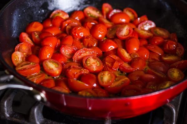 Grape tomatoes sauteed in a skillet.