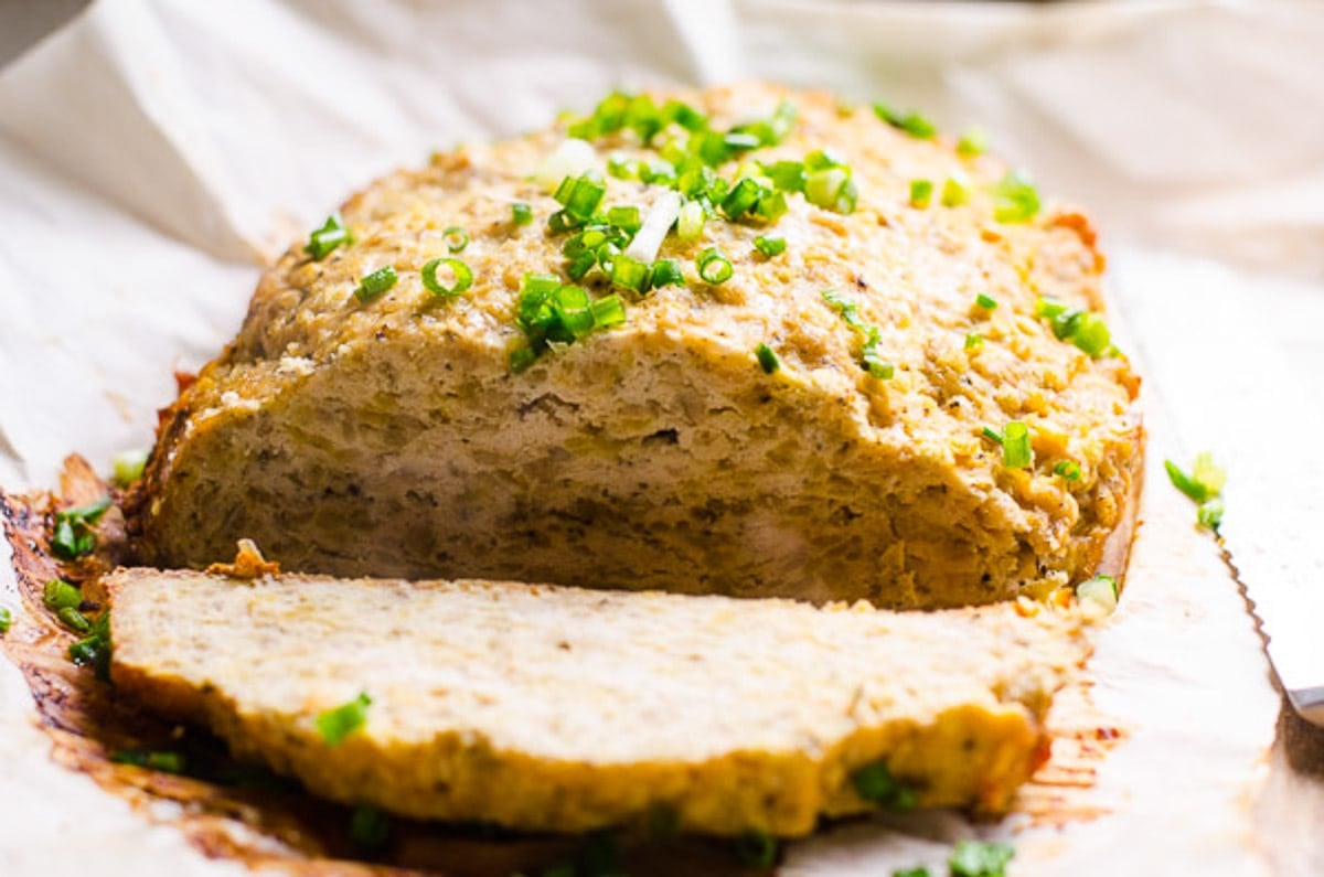 Sliced slow cooker turkey meatloaf with garnish.