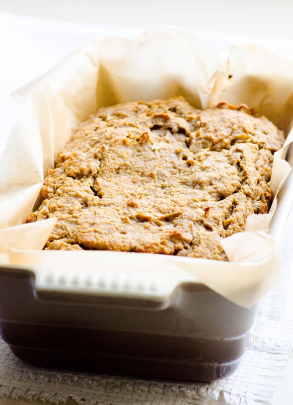 Coconut flour banana bread in a loaf pan lined with parchment paper.