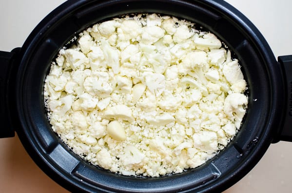 Chopped cauliflower with water in a slow cooker.