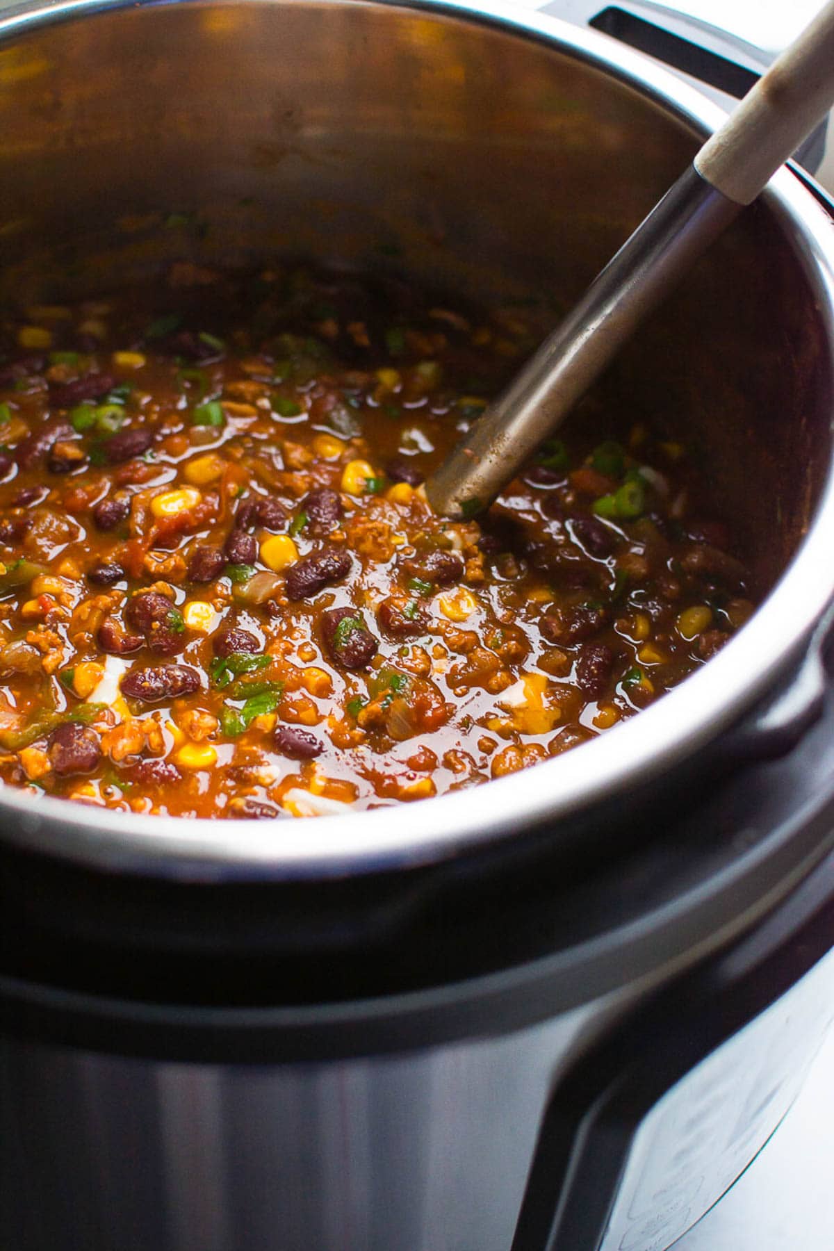 Turkey chili with a ladle in the pressure cooker pot.