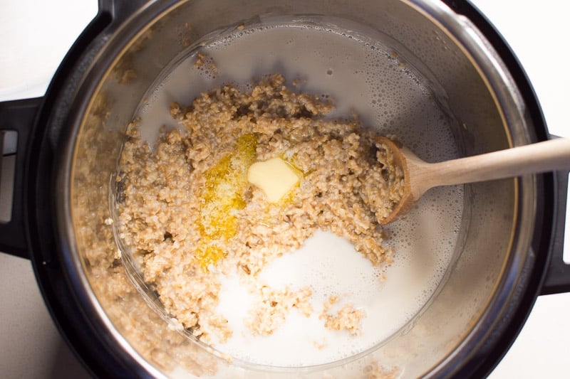 stirring instant pot steel cut oats with milk and butter stirring to incorporate