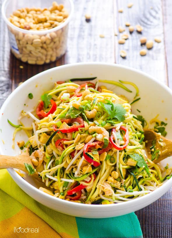 Pad Thai zucchini noodles garnished with cilantro in serving bowl with wooden spoons.