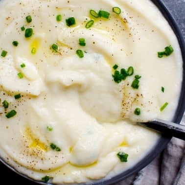 Cauliflower mashed potatoes with chives in a bowl.