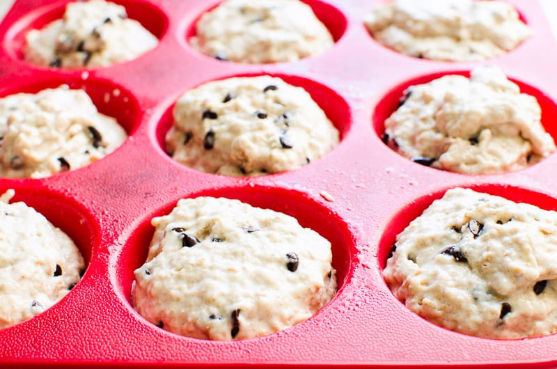 Healthy chocolate chip muffins in red silicone muffin tin ready to bake.