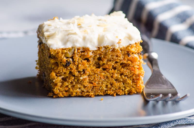 healthy carrot cake with frosting served on a blue plate with fork