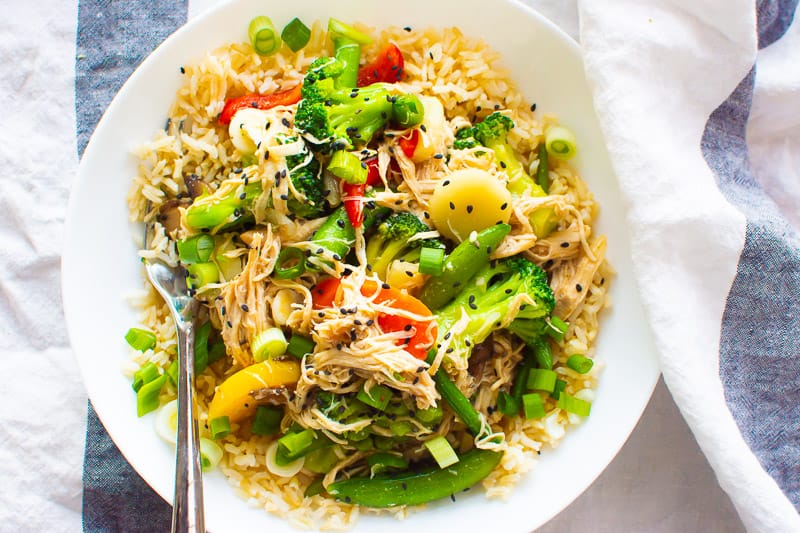 instant pot stir fry served over brown rice on a white plate with a fork