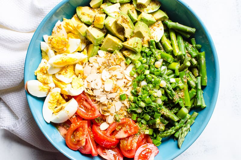 A blue bowl with asparagus salad. 