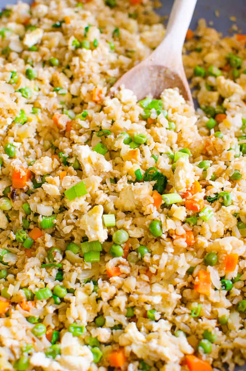 Cauliflower fried rice with peas, carrots and egg in skillet. 