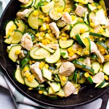 Chicken and corn with zucchini and cast iron skillet.