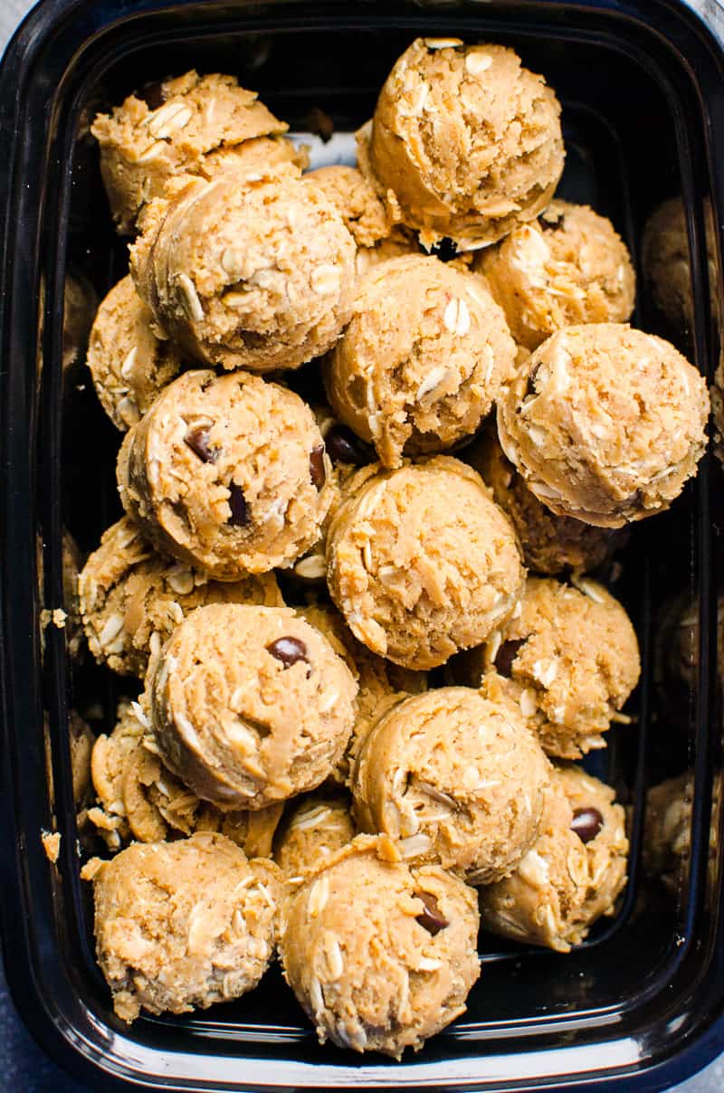 Peanut butter protein balls with plant-based protein powder in black container.