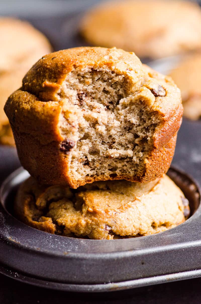 Almond flour banana muffins stacked on top of each other with one showing texture inside.