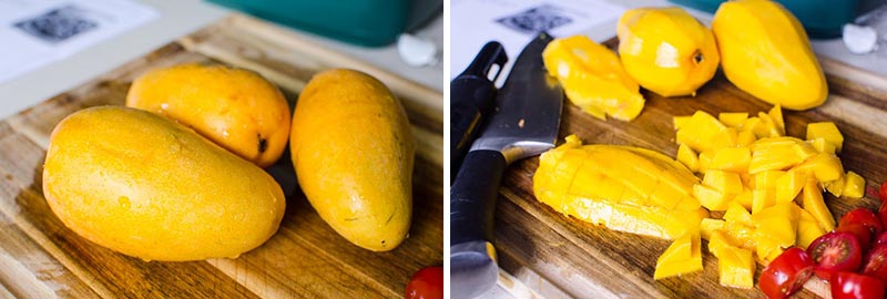 Whole and then chopped mango and tomatoes on a cutting board.