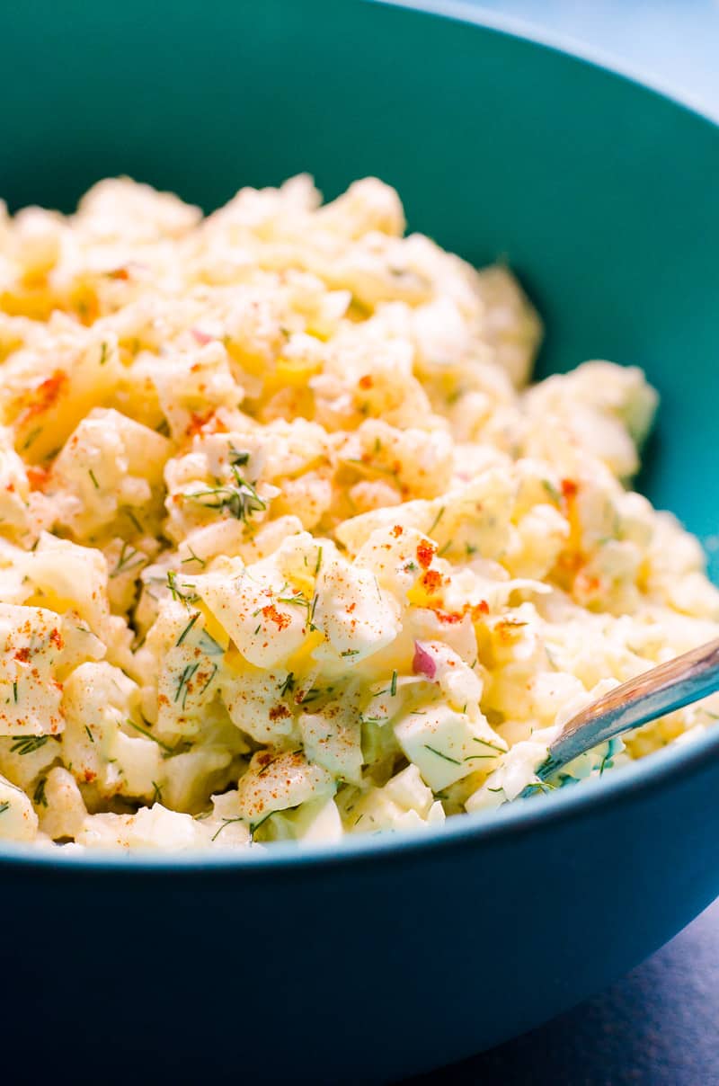 Cauliflower Potato Salad served in a bowl with a spoon.