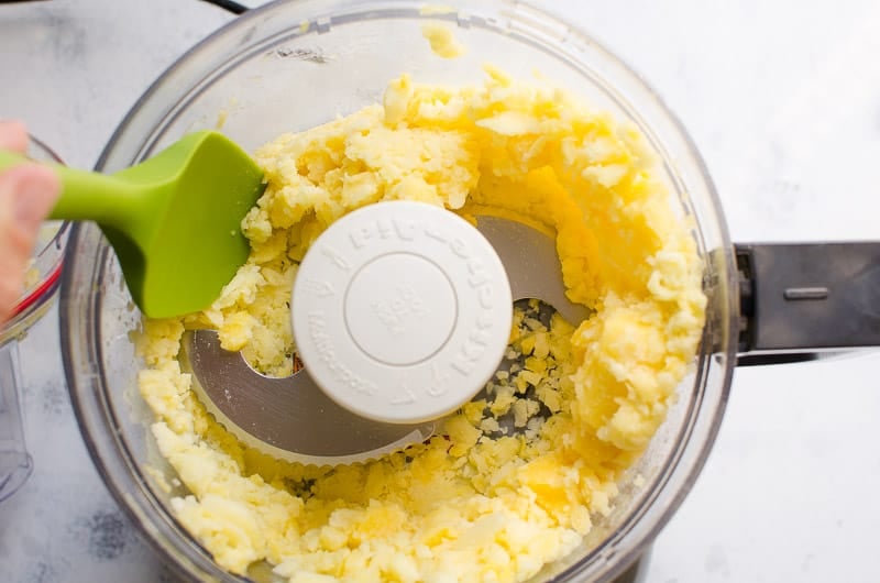 frozen pineapple chunks and green spatula in a food processor