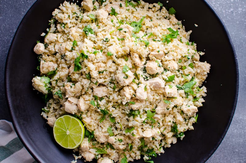 Cilantro Lime Cauliflower Rice on plate served with slice of lime