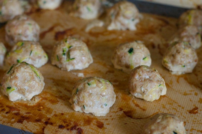 healthy ground turkey meatballs on baking sheet being baked