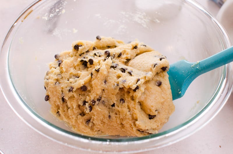 glass bowl with almond flour cookie dough and blue spatula