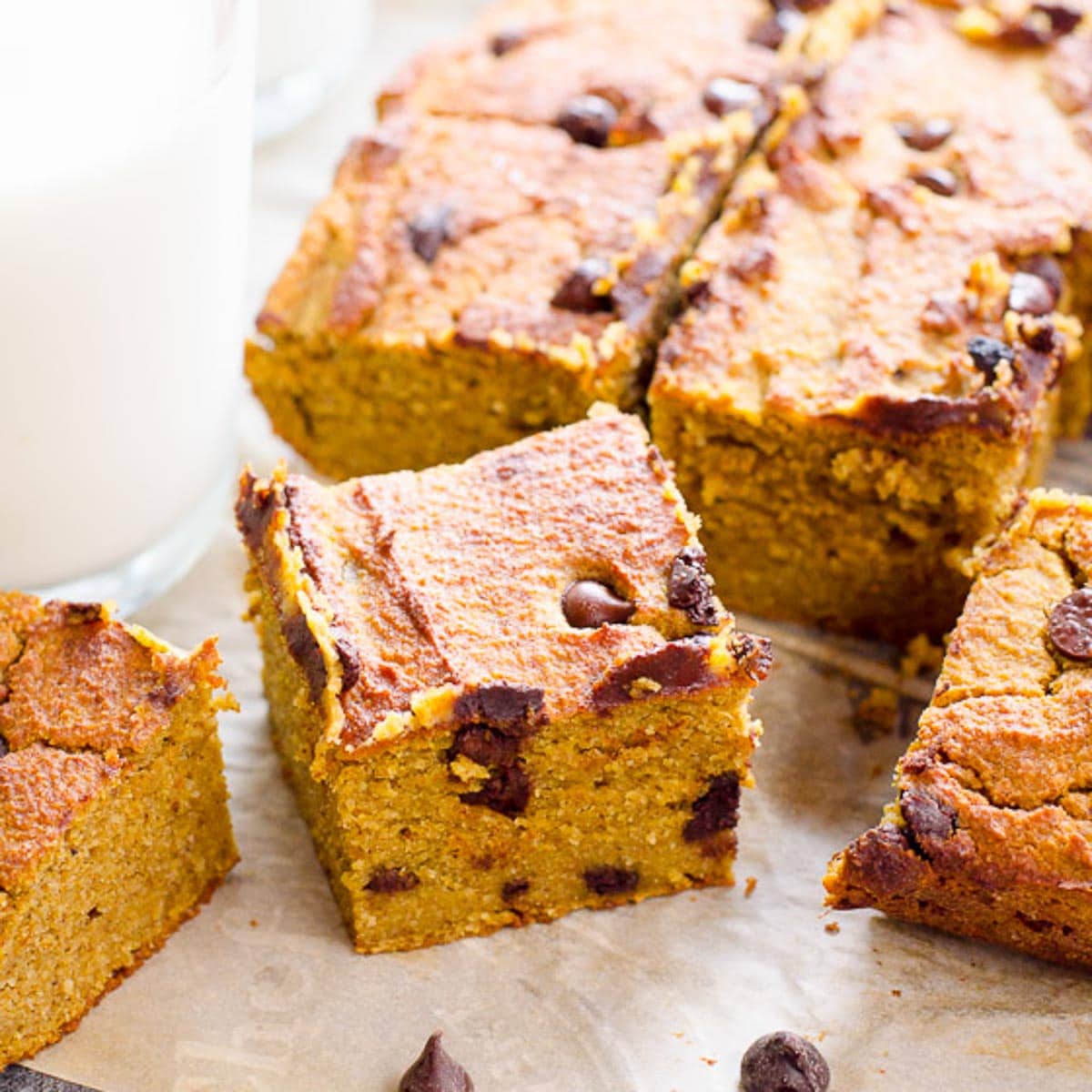 Healthy pumpkin bars cut into squares with a glass of milk.