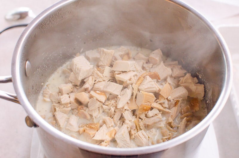 Cubed chicken in large stockpot with milk.