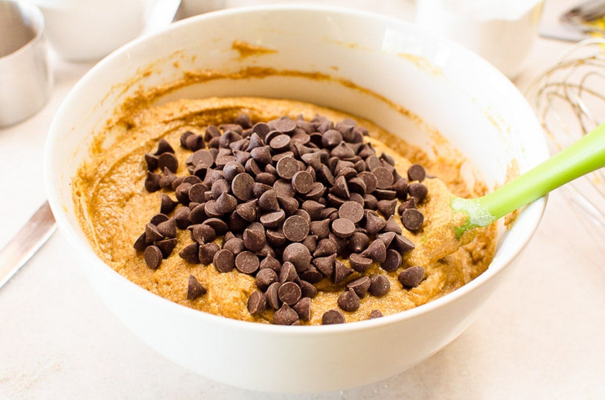 Chocolate chips in bowl with pumpkin bread batter.