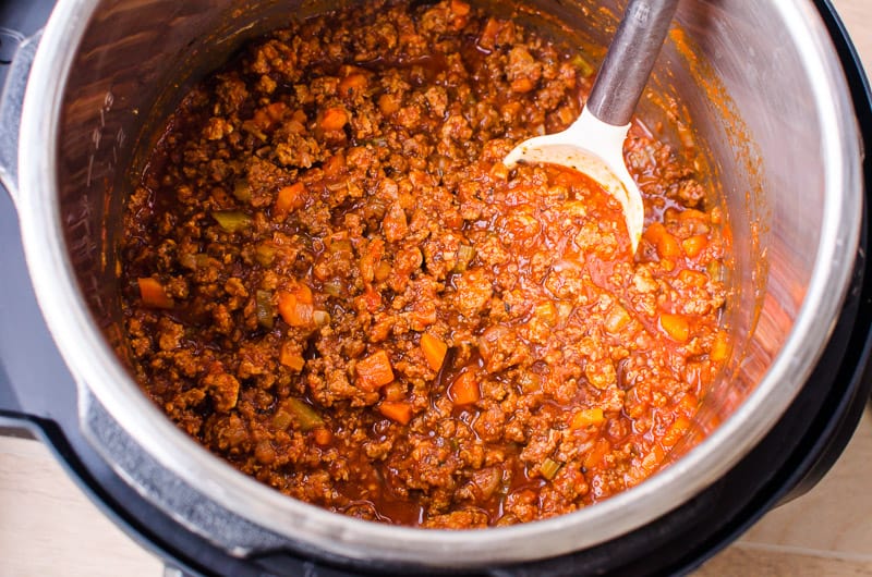 cooked Instant Pot Bolognese sauce in pressure cooker with spoon